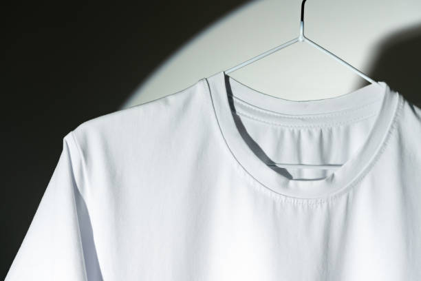 istock Blank T-shirt hanging in a spotlight in studio 1974389828