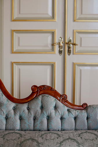 Victorian-style light blue armchair featuring exquisite wooden carving details, adding a touch of elegance and sophistication to its design.