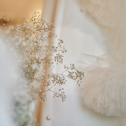 A bouquet of gypsophila delicately rests on the table, captured in soft focus, adding an ethereal touch to the scene.