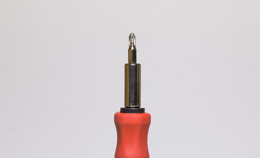 A closeup of a screwdriver's head on a white background