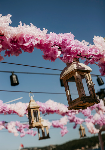 A glass Cherry Blossoms and tealight hanging elegantly on a string against a blue sky. stock photo