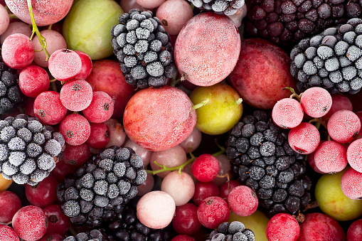 Close up of frozen mixed berries - red currant, white currant, blackberry, gooseberry and black currant.