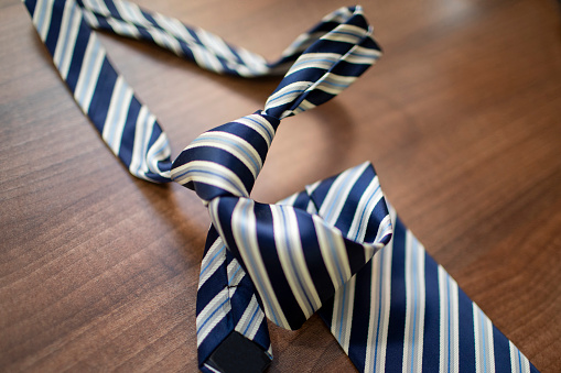 Blue striped tie on a dark wooden table