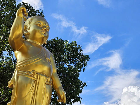 Golden Little Buddha Image with Blue Sky Background.