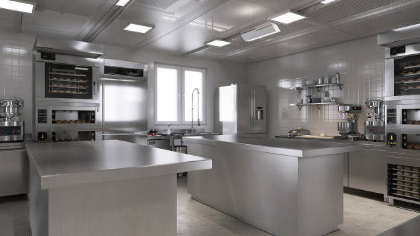 istock Empty clean stainless steel island table in commercial, professional bakery kitchen with convection, deck oven, freezer, refrigerator, shelf, cabinet, equipment in background 1974525867