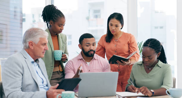 istock Business people, laptop and meeting teamwork, collaboration and planning with notebook for ideas. Professional manager, women and men watch or reading on computer for office presentation or training 1974533880