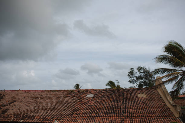 A tropical style building roof against a blue sky background.