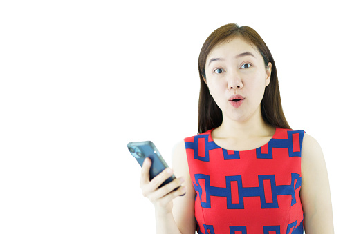 Asian businesswoman shows her looking excitedly at her mobile phone. The woman in casual attire is reading content on her phone with excitement.