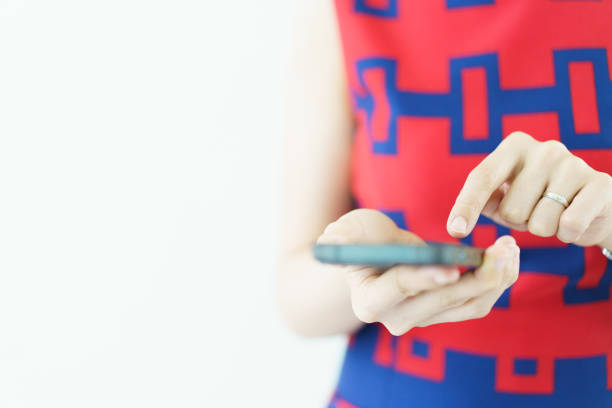 Asian businesswoman shows her looking excitedly at her mobile phone. The woman in casual attire is reading content on her phone with excitement.