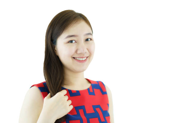 Good looking and beautiful Asian young woman in casual red attire touching her beautiful brown hair on white background. Happy Asian woman looking at her hair.