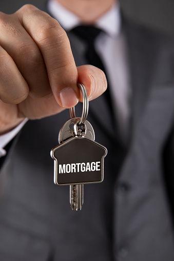 Businessman is holding house keychain for mortgage concept