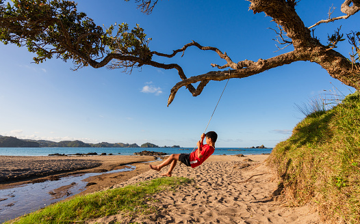 Kids out at beach playing and enjoying themselves in Northland, New Zealand.