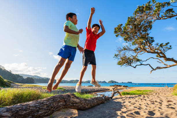 istock Kids at beach jumping enjoying outdoors. 1974569241