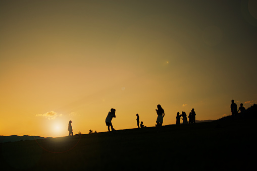 Silhouette people standing on the hill under sunshine light