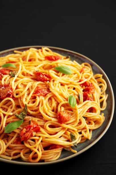 istock Homemade Spaghetti Pasta with Fresh Tomato Sauce on a Plate on a black surface, side view. 1974581855