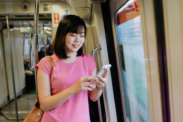 istock Young asian woman using smartphone while riding the train 1974587223