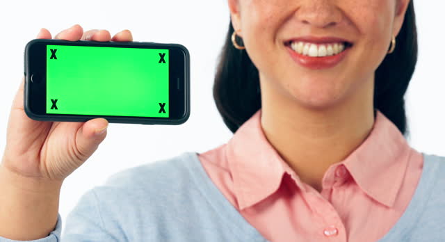 Hands, woman and advertising phone with green screen, space and sign up offer in studio on white background. Happy model, face and tracking markers on mobile for mockup, promotion and launch deal