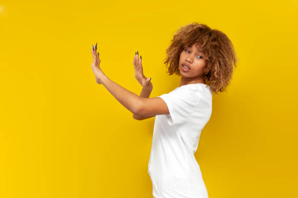 istock young curly american girl refuse and avoid with hands on yellow isolated background, african woman shows refusal 1974641022