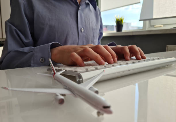 istock Airplane and persons on laptop keyboard 1974645830