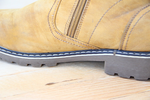Shabby yellow shoes on a wooden background, close-up