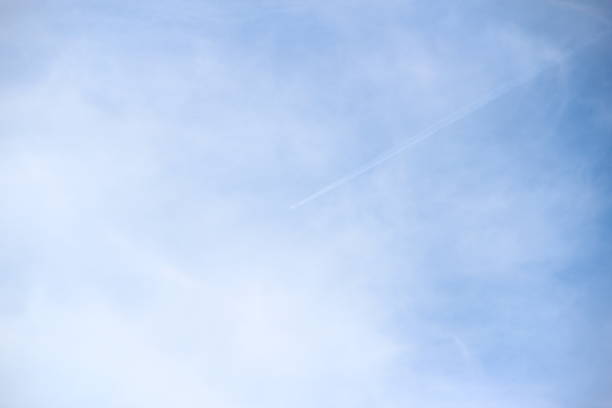 Plane flies high in the sky among the clouds