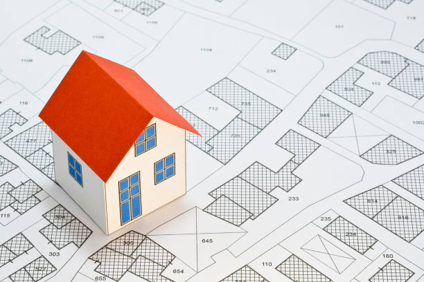 Cadastral map with buildings, building plot and free land parcel for house construction - building activity and permit concept with home model