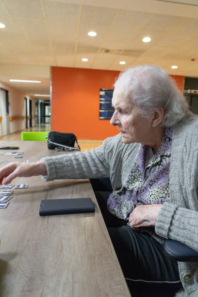 istock Elderly woman playing a board game in a nursing home 1974683564