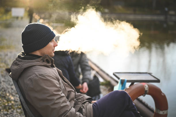 fumar cigarro eletrônico ao ar livre na hora da pesca. - quit lake - fotografias e filmes do acervo