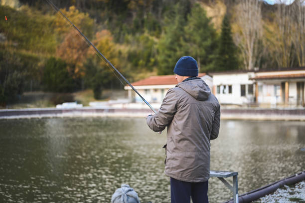 man fishing outdoors in a pond.