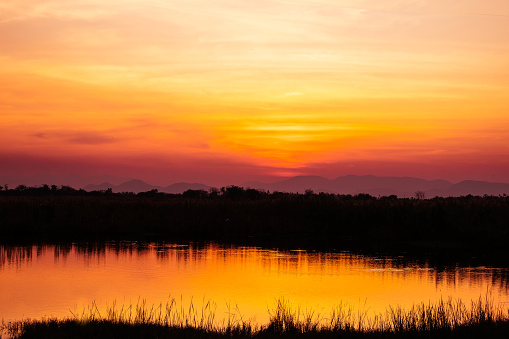 Landscape of beautiful dramatic golden orange sunset sky with  reflection.
