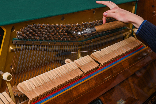 the piano tuner's hand and instrument. close-up