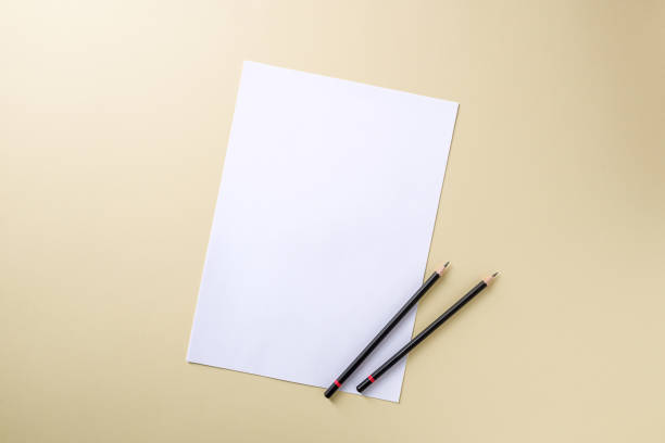 istock Blank white paper and black pencil on yellow background 1974715085