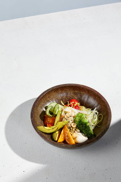 istock Salad bowl with avocado, mixed vegetables, and poached egg in bright sunlight 1974737300