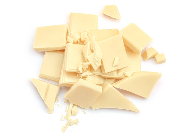 istock Broken white chocolate pieces  isolated on white background. Cubes of irregular chocolate shape for package design. Top view. Flat lay 1974739969