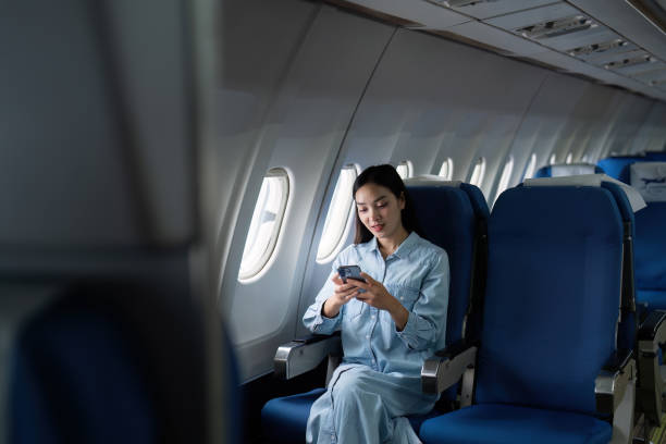 istock Asian people female person onboard, airplane window, using mobile while on the plane 1974752791