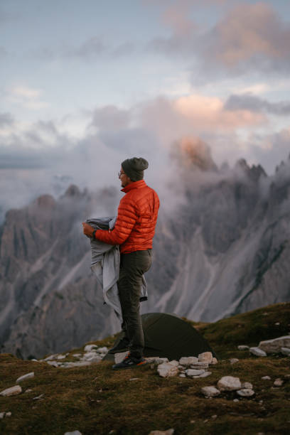 istock Peaceful scenery of sharp cliffs and mountain peaks above the clouds. Tourist hiker standing and  enjoying the view 1974778164