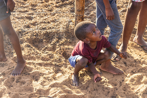 african kids playing in the sand , severe drought affecting the usual ecosystem