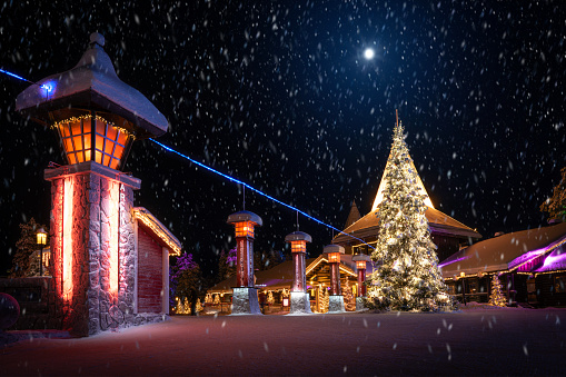 Arctic Circle Line in Santa's Village in Rovaniemi Finland on a snowy winter night. Visitors enter the Arctic circle by crossing this line and it is also possible to get a certificate. The park is open to Public and there is no entrance fee.