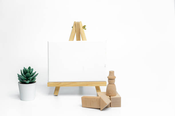 istock Wooden doll with empty easel on white background; business or creative concept 1974818585
