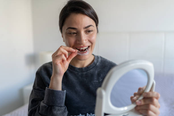 istock Woman Applying Invisible Teeth Aligner 1974819101