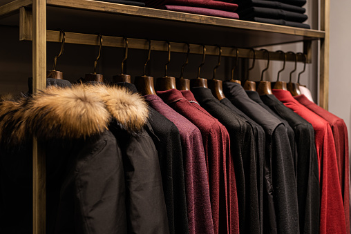 wardrobe with men's clothes in dark colors, burgundy color. jacket, down jacket, shirt. men's shirt earth tone color polite color for work or casual wear Orderly with wood hanger there are Separated by color make easy to pick up
