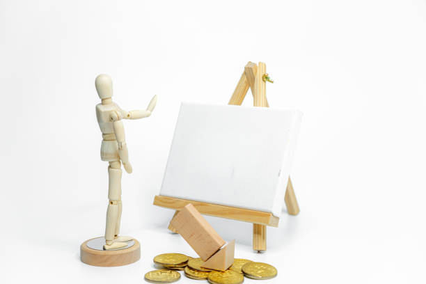 Wooden doll with empty easel on white background; business or creative concept