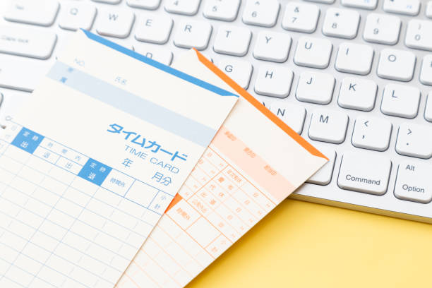 istock Keyboard and time card on yellow background 1974844456
