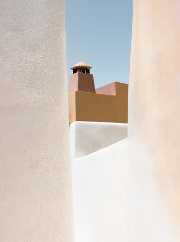 Pastel minimalistic building in orange tones in Emborio, Santorini, Greece with focus in the background