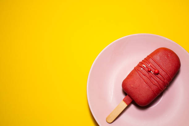 Square shot of three ice cream popsicles in pink plate