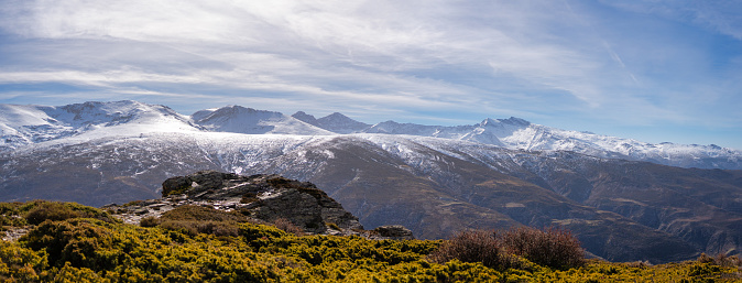 Expansive view of the Sierra Nevada range featuring prominent peaks such as Mulhacen, Veleta, Alcazaba, Puntal de Vacares, La Atalaya, and Cerro de los Machos.