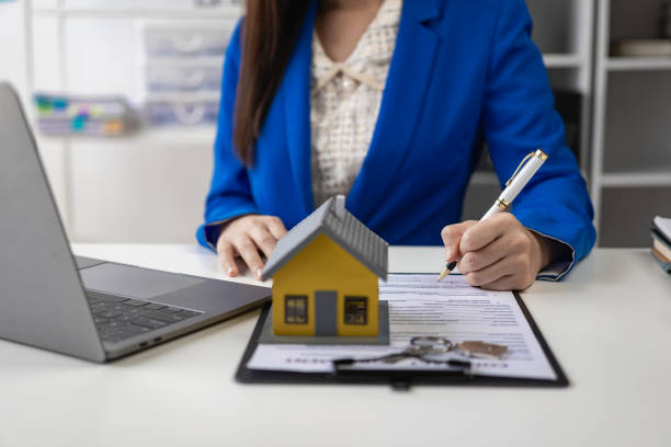 Real estate agent, young woman holding house and house keys, selling or renting property, moving house or renting property, small house, property insurance and real estate concept in office agente de bienes raíces, mujer joven que sostiene la casa y las llaves de la casa, venta o alquiler de la propiedad, mudanza de la casa o alquiler de la propiedad, casa pequeña, seguro de propiedad y concepto de bienes raíces en la oficina