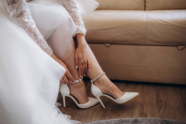 istock Bride puts on wedding shoes on her tender feet 1974884362