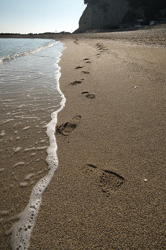 Footprints on sandy beach at sunset time