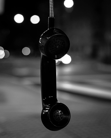 Telephone booth with reflected city lights